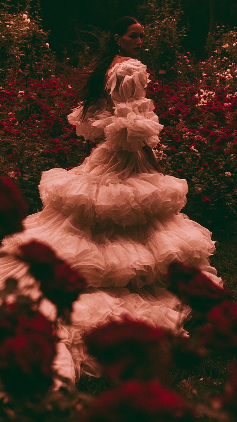 Tiered ivory couture gown in a rose garden